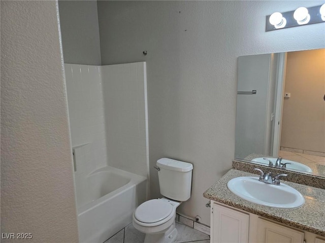 bathroom with a textured wall, toilet, vanity, and tile patterned floors