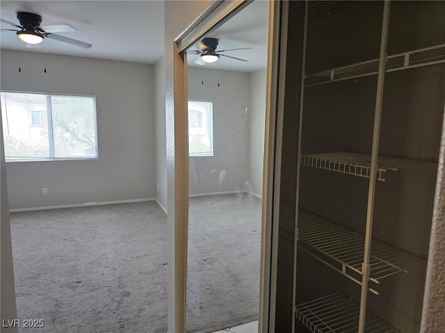bathroom featuring ceiling fan and baseboards