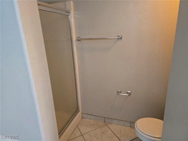 full bath with a shower stall, tile patterned floors, and toilet