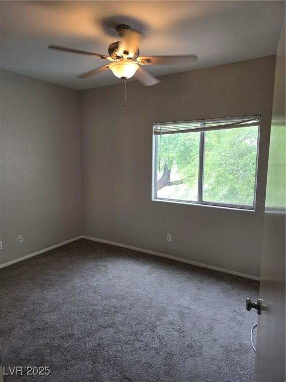 empty room featuring carpet, a ceiling fan, and baseboards