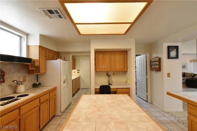 kitchen with white appliances, tile countertops, light tile patterned floors, and backsplash