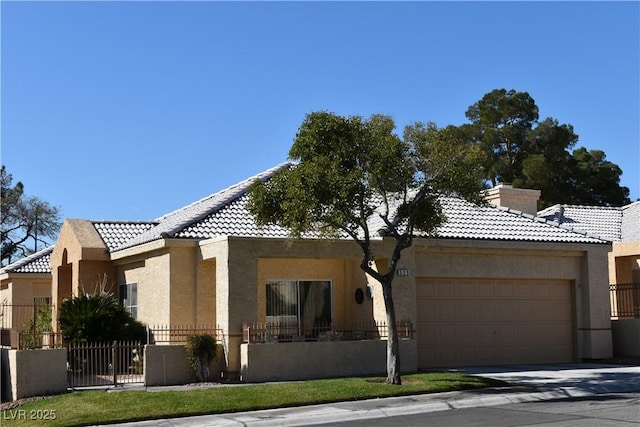 view of front of house with a tile roof, stucco siding, an attached garage, fence, and a chimney