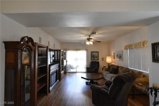 living room featuring dark wood finished floors and a ceiling fan