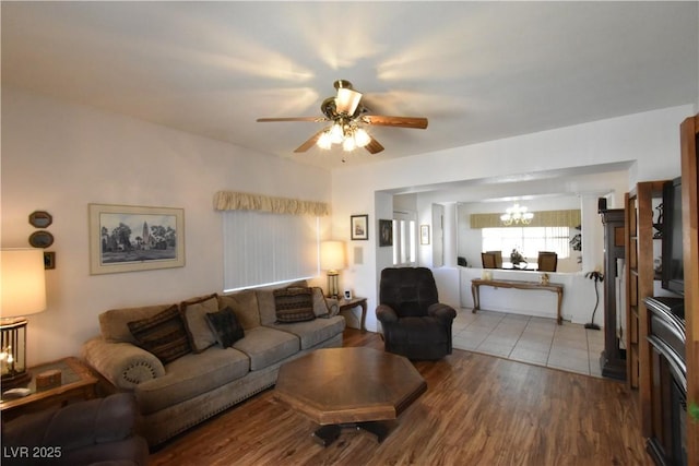 living room featuring a chandelier, a ceiling fan, and wood finished floors