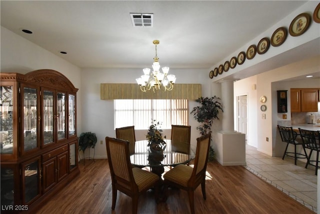dining space featuring a chandelier, wood finished floors, and baseboards