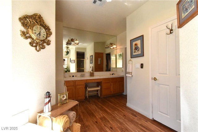 bathroom with wood finished floors and double vanity
