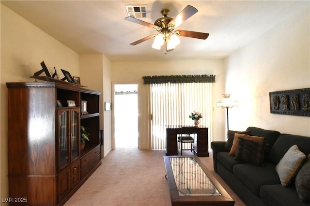 carpeted living area with a ceiling fan