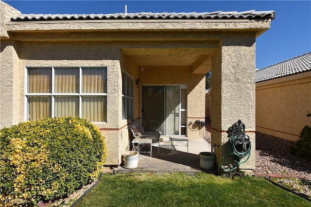 entrance to property with a patio area and stucco siding