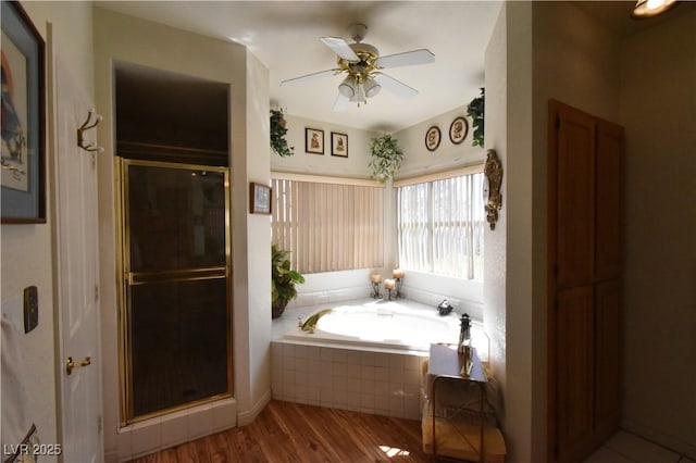 full bath featuring a stall shower, a bath, wood finished floors, and a ceiling fan