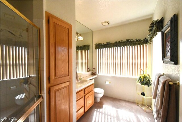 full bath with plenty of natural light, a stall shower, vanity, and toilet