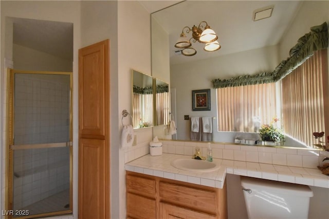 bathroom featuring a shower stall, vanity, and a chandelier