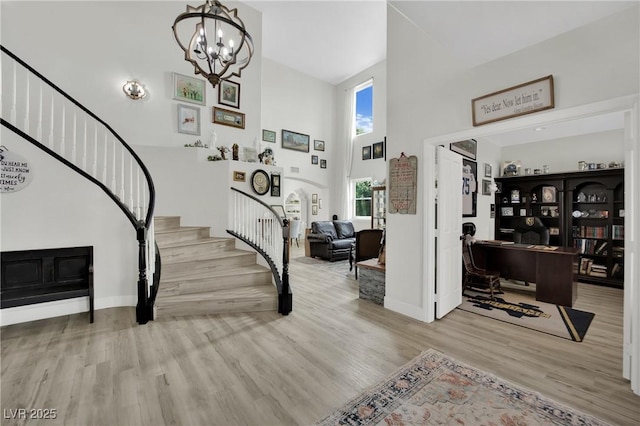 7211 Heggie Ave, Las Vegas, NV 89131 - entrance foyer with stairs, a high ceiling, wood finished floors, a chandelier, and baseboards