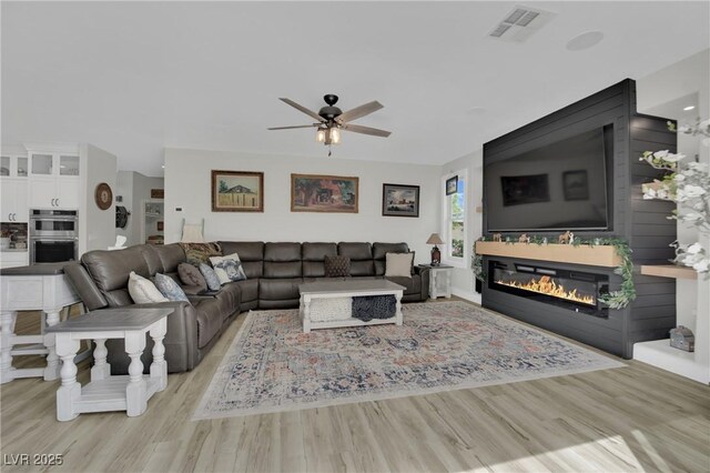 7211 Heggie Ave, Las Vegas, NV 89131 - living room with a ceiling fan, wood finished floors, and a glass covered fireplace