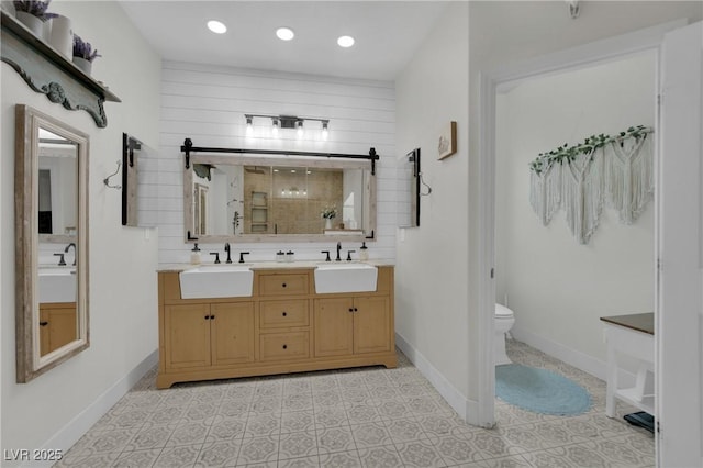 7211 Heggie Ave, Las Vegas, NV 89131 - bathroom featuring a stall shower, double vanity, toilet, recessed lighting, and baseboards