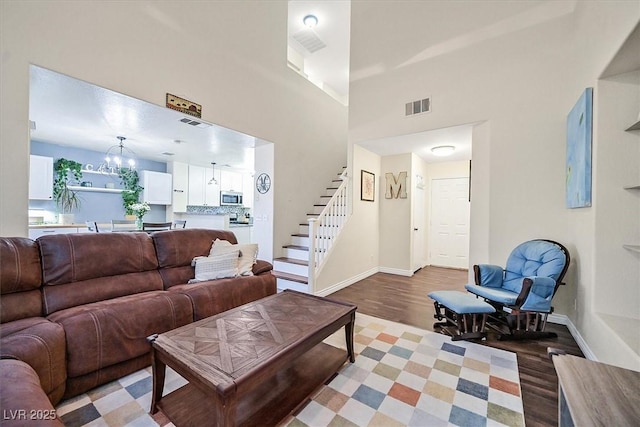 4820 Integrity St, North Las Vegas, NV 89031 - living room with stairs, light wood-type flooring, baseboards, and a chandelier