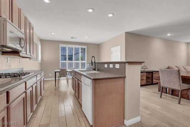 3141 Monet Sunrise Ave, Henderson, NV 89044 - kitchen featuring white appliances, a sink, light wood finished floors, a kitchen island with sink, and recessed lighting