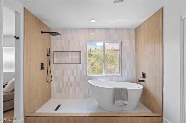 bathroom featuring a tile shower and a freestanding tub