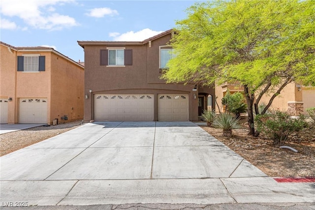 view of front of property featuring a garage, concrete driveway, and stucco siding
