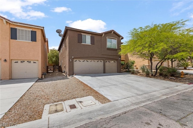view of front of property featuring driveway, an attached garage, and stucco siding