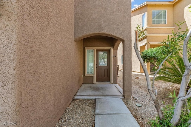 view of exterior entry featuring stucco siding