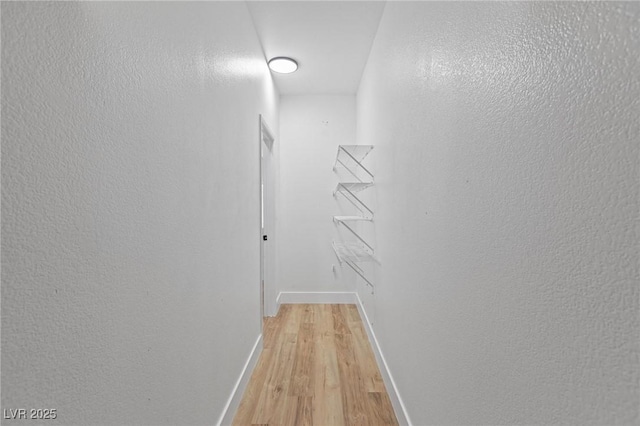 hallway with light wood finished floors and baseboards