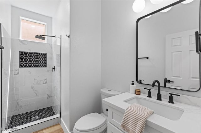 full bath featuring toilet, a marble finish shower, and vanity