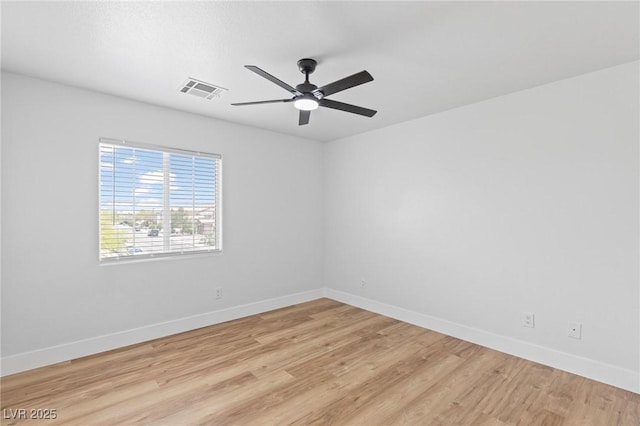 unfurnished room featuring a ceiling fan, light wood-style flooring, and baseboards