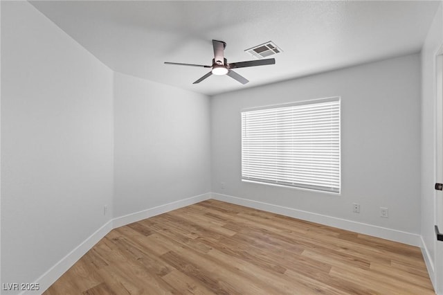 spare room featuring ceiling fan, light wood-type flooring, and baseboards