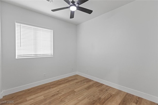 spare room with baseboards, light wood-style flooring, and ceiling fan