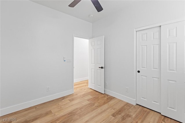 unfurnished bedroom with light wood-style flooring, baseboards, a closet, and a ceiling fan
