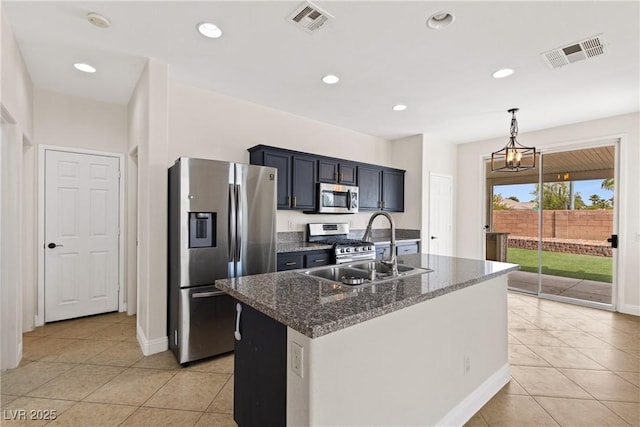 kitchen featuring appliances with stainless steel finishes, light tile patterned floors, a sink, dark stone countertops, and recessed lighting