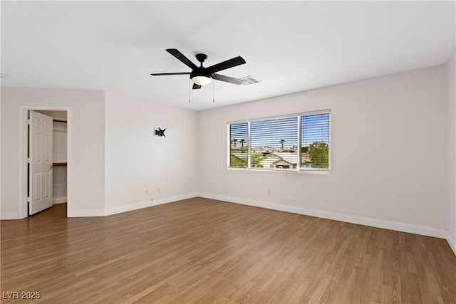 unfurnished room featuring light wood-style flooring, baseboards, and a ceiling fan