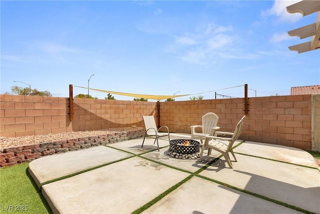 view of patio / terrace with an outdoor fire pit and fence