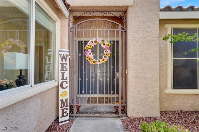8608 Willow Cabin St, Las Vegas, NV 89131 - view of exterior entry with stucco siding and a gate