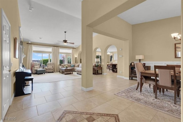 8608 Willow Cabin St, Las Vegas, NV 89131 - dining space featuring a ceiling fan, light tile patterned floors, a high ceiling, arched walkways, and a chandelier