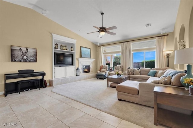 8608 Willow Cabin St, Las Vegas, NV 89131 - living area with lofted ceiling, a ceiling fan, light tile patterned floors, a tiled fireplace, and built in shelves
