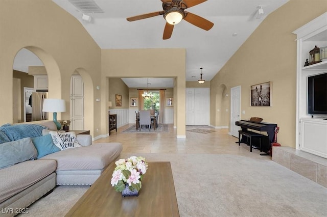 8608 Willow Cabin St, Las Vegas, NV 89131 - living room featuring arched walkways, a ceiling fan, high vaulted ceiling, light colored carpet, and baseboards