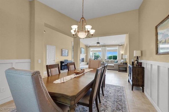 8608 Willow Cabin St, Las Vegas, NV 89131 - dining space featuring a decorative wall, ceiling fan, a chandelier, wainscoting, and light tile patterned flooring