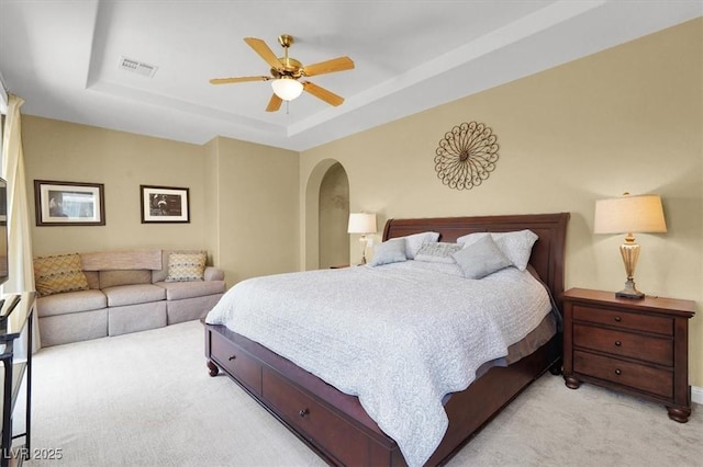 8608 Willow Cabin St, Las Vegas, NV 89131 - bedroom featuring light carpet, a tray ceiling, arched walkways, and ceiling fan