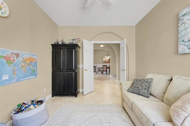 8608 Willow Cabin St, Las Vegas, NV 89131 - living room with light tile patterned floors, arched walkways, ceiling fan, a chandelier, and baseboards