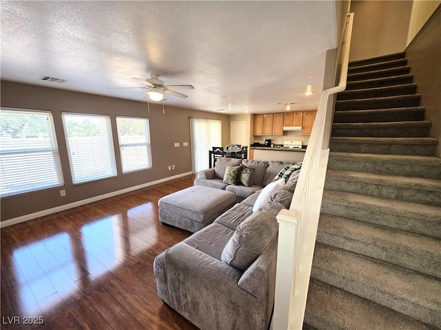 living area featuring baseboards, a ceiling fan, stairway, and dark wood-style flooring
