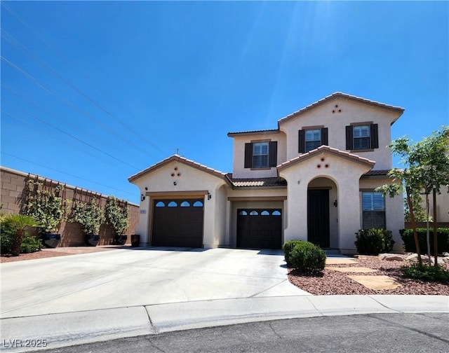 mediterranean / spanish house with stucco siding, a tiled roof, concrete driveway, and an attached garage