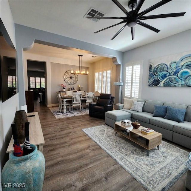 living room with ceiling fan, dark wood finished floors, a chandelier, and baseboards