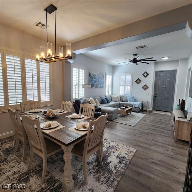 dining area with a chandelier, wood finished floors, baseboards, and a ceiling fan