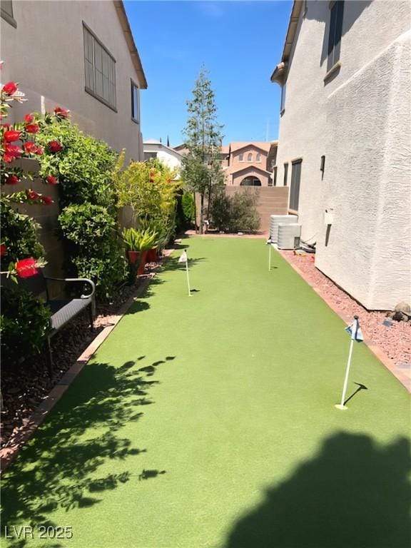 view of yard with an area to practice putting and central AC unit
