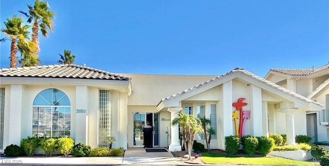 property entrance featuring stucco siding and a tiled roof