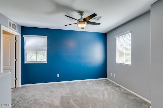 spare room with ceiling fan, carpet, and baseboards