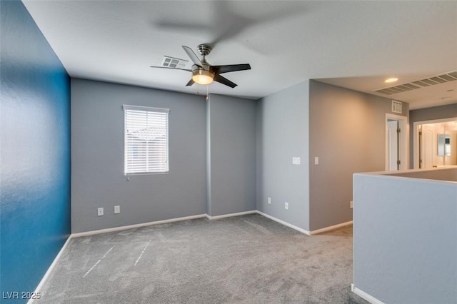 carpeted empty room featuring a ceiling fan and baseboards