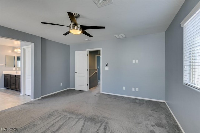 unfurnished bedroom with baseboards, light carpet, multiple windows, and ceiling fan