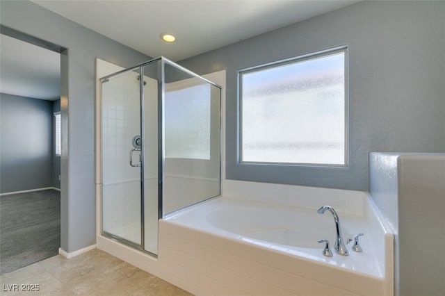bathroom featuring a shower stall, a garden tub, and tile patterned floors